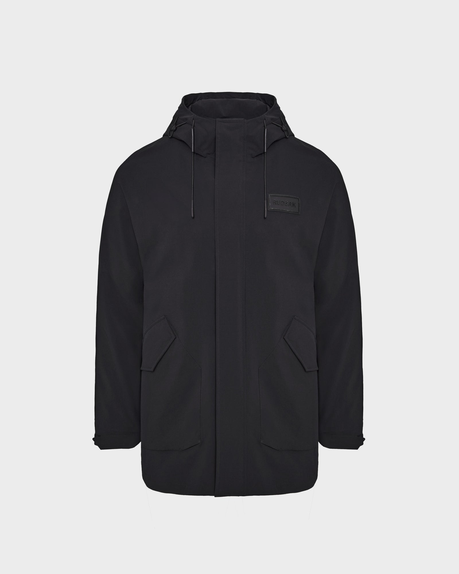 The Rudsak IAN - 6124009 Black mens long raincoat features a high collar, hood with adjustable drawstrings, front zipper, two large flap pockets, and water-repellent fabric, shown on a plain white background.