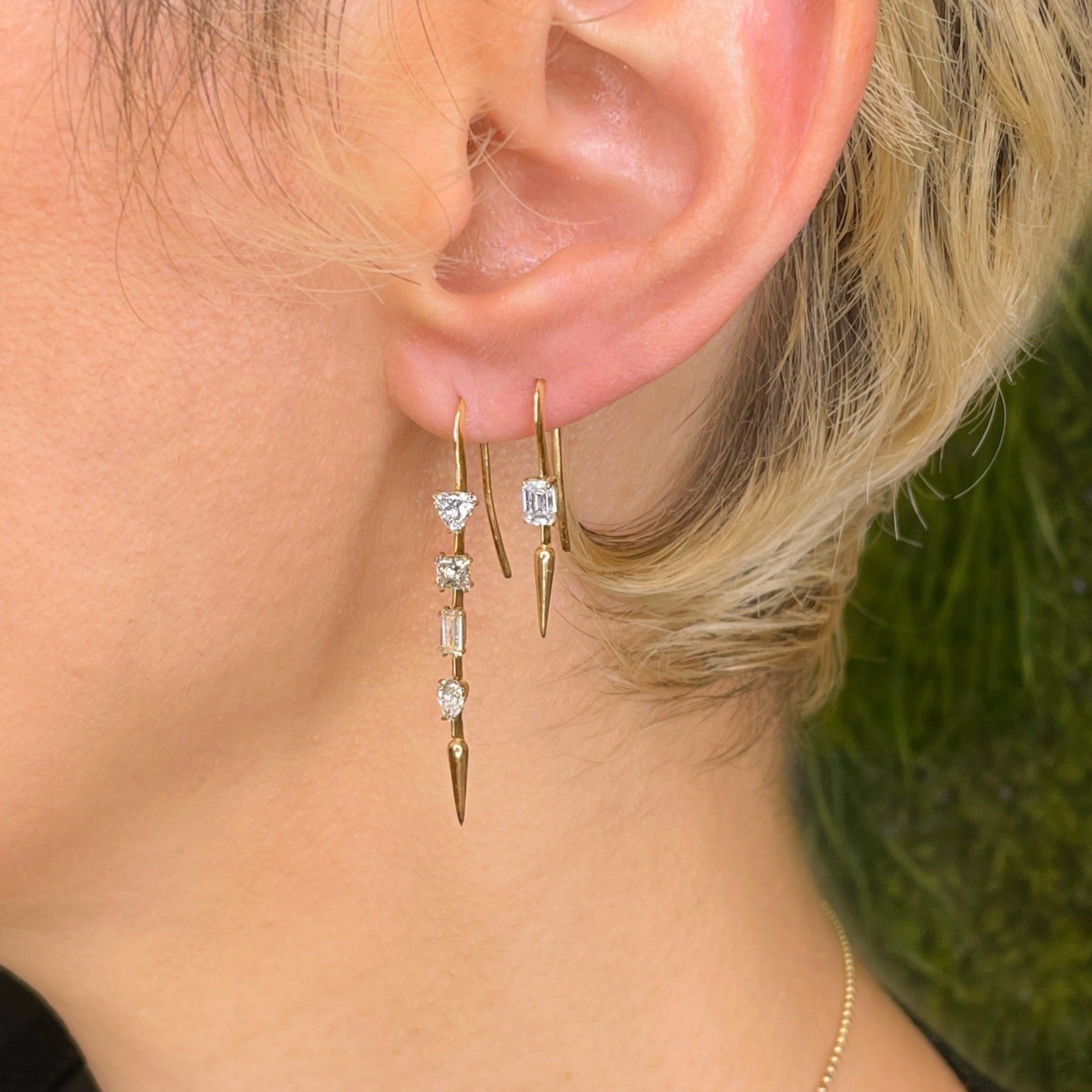 14k gold Single Diamond Drop Earrings in emerald cut on an ear