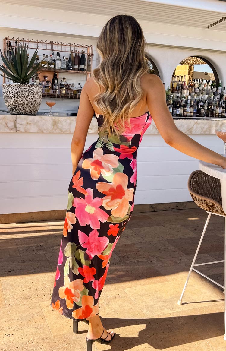Close-up of the twisted bodice and front cutout with ruched detail on a black floral midi dress