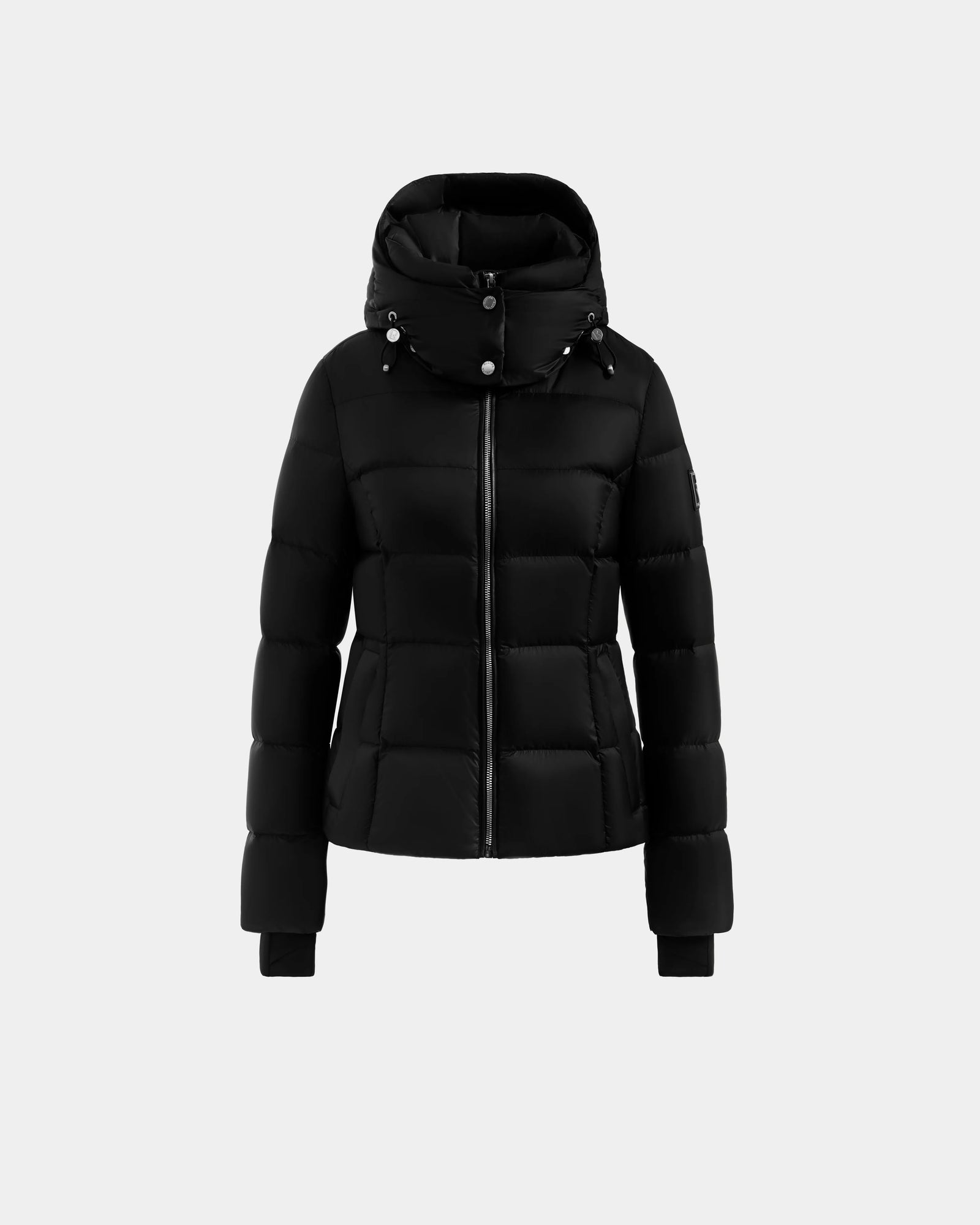 The Rudsak KATIA - L125564 Black is a weather-resistant puffer jacket with a front zipper, detachable hood, snap buttons, and long sleeves, shown on a plain light gray background.