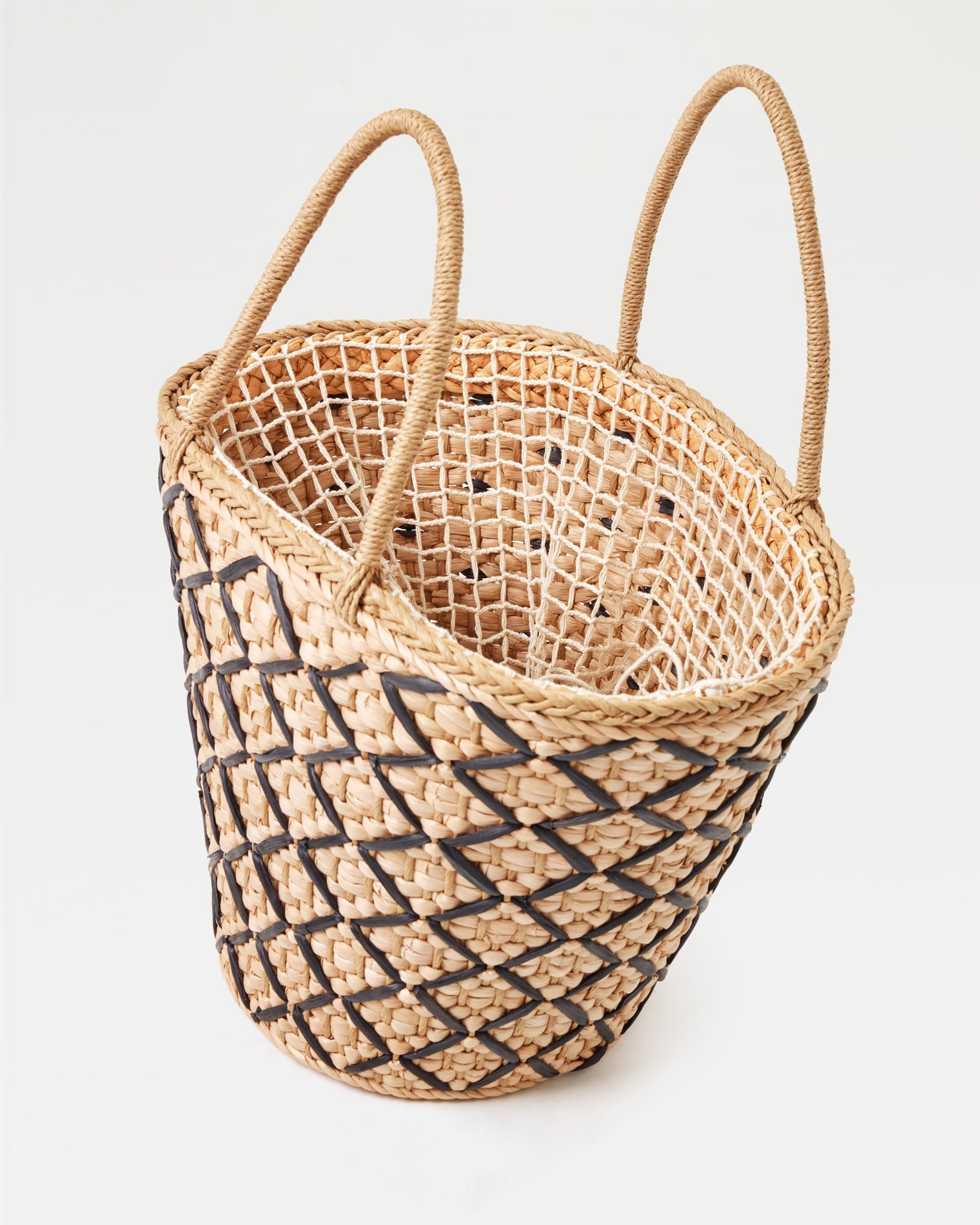 Top-down angled view of the Palma Nights Bag in natural-black showing the open interior, lattice weave pattern, and double rope handles.