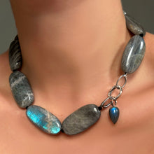Labradorite Long Oval Necklace with Round pavé face charm lock and Labradorite drop charm on recycled white gold ripple bale on a model's neck.