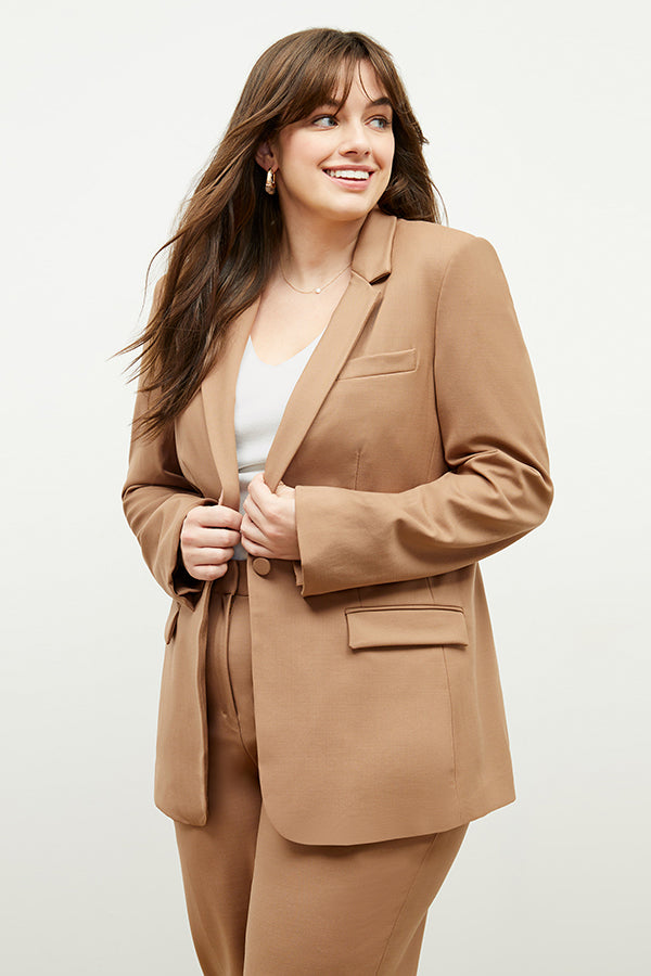 Front image of a woman standing wearing the Yiyan Blazer in Camel | Exclude