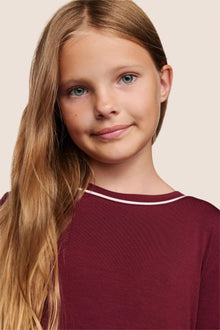 Model is wearing Kids TENCEL Modal Unisex Long PJ Set  in Bordeaux/Ivory