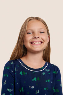 Model is wearing Kids Printed TENCEL Modal Unisex Long PJ Set  in Forest Pine Navy/Ivory