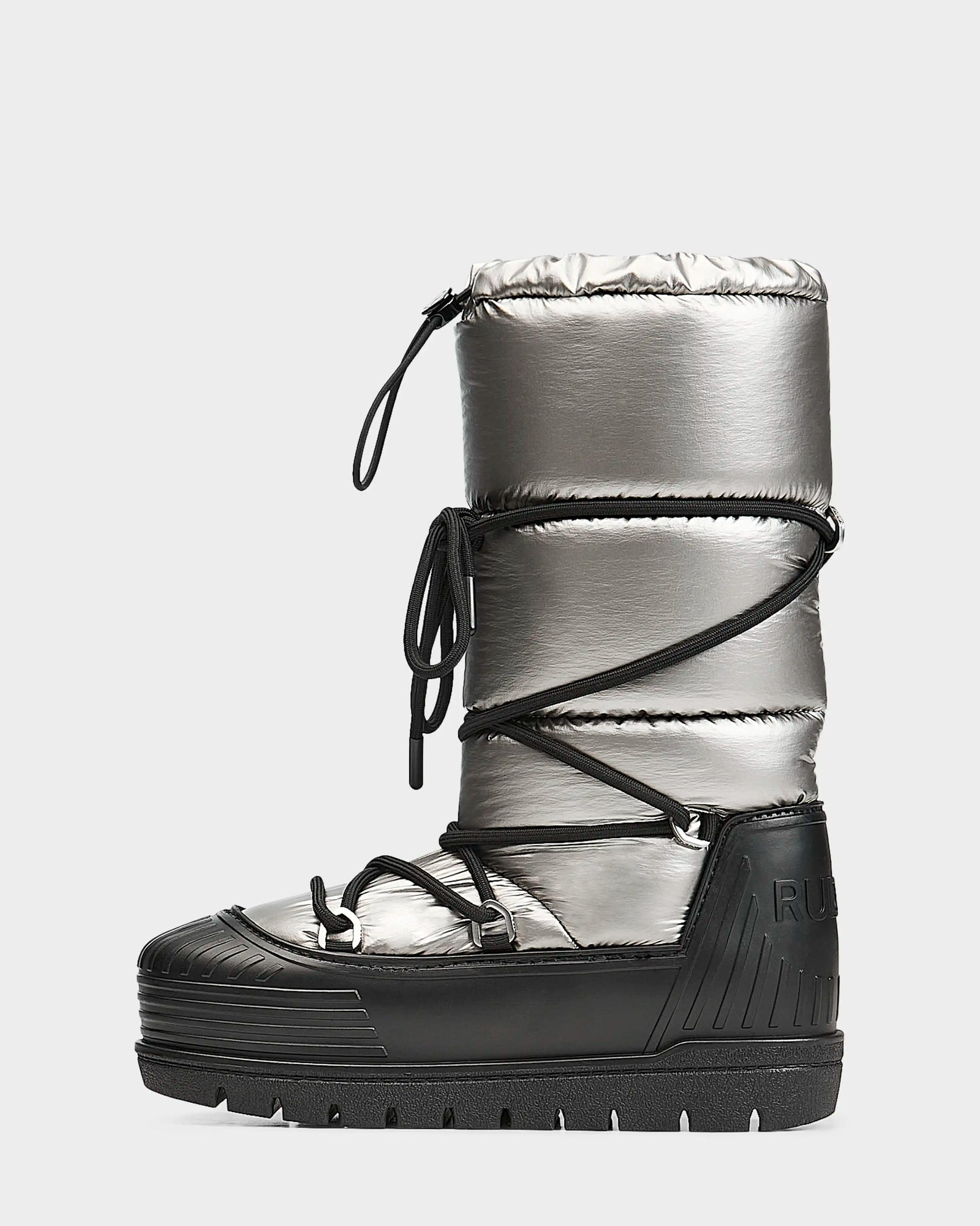 The Rudsak TISH - L223508 Pewter is a womens winter boot in metallic silver and black, featuring thick padding, black front crisscross laces, a chunky platform sole, and RUB embossed on the heel.