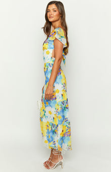 Side view of a blue floral chiffon maxi dress with flutter sleeves and waist cutouts