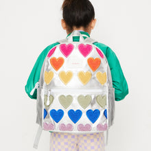 Girl wearing fuzzy hearts backpack