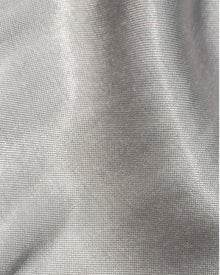 Close-up of the LSPACE Sweet As Honey Skirt in silver, showing the luminous woven satin fabric texture with a metallic silver sheen.