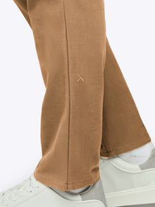 Brown pants worn with white sneakers on a white background