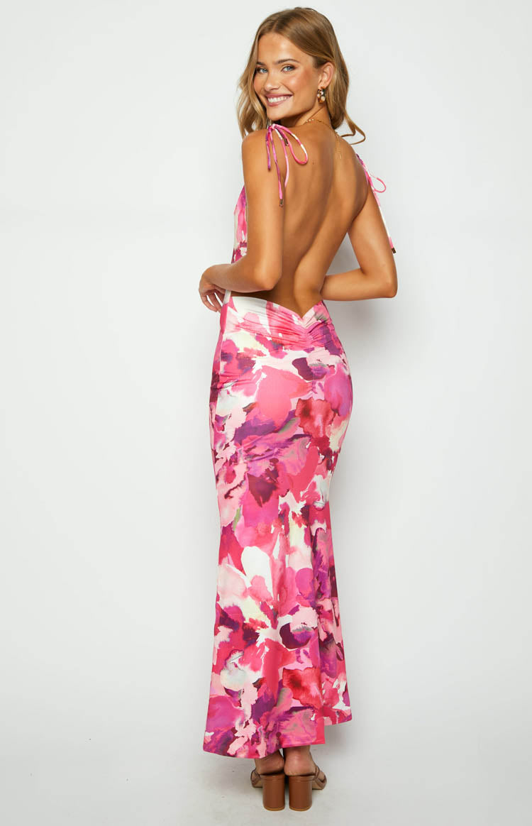 Rear view of a pink print maxi dress with tie-up spaghetti straps, a white upper back panel, low scoop back, and ruched waist