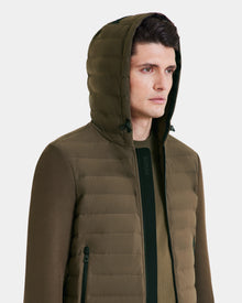 A person wearing the Rudsak DEE MAT - 6124028 Army mens olive green lightweight hybrid down jacket with zipper and side pockets, looking slightly to the side against a plain light background.