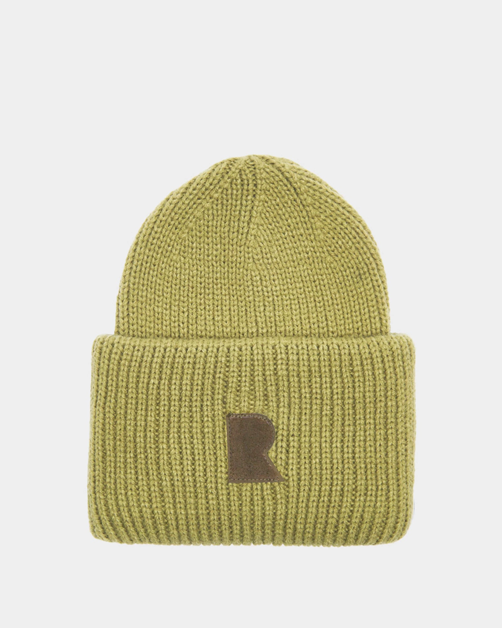 The Rudsak MURRAY - U423503 Light Olive is a unisex ribbed knit beanie with a wide folded brim and a front brown patch with a bold letter R, adding urban flair against a light gray background.