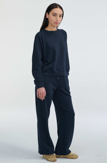 Person wearing a navy blue outfit on a white background