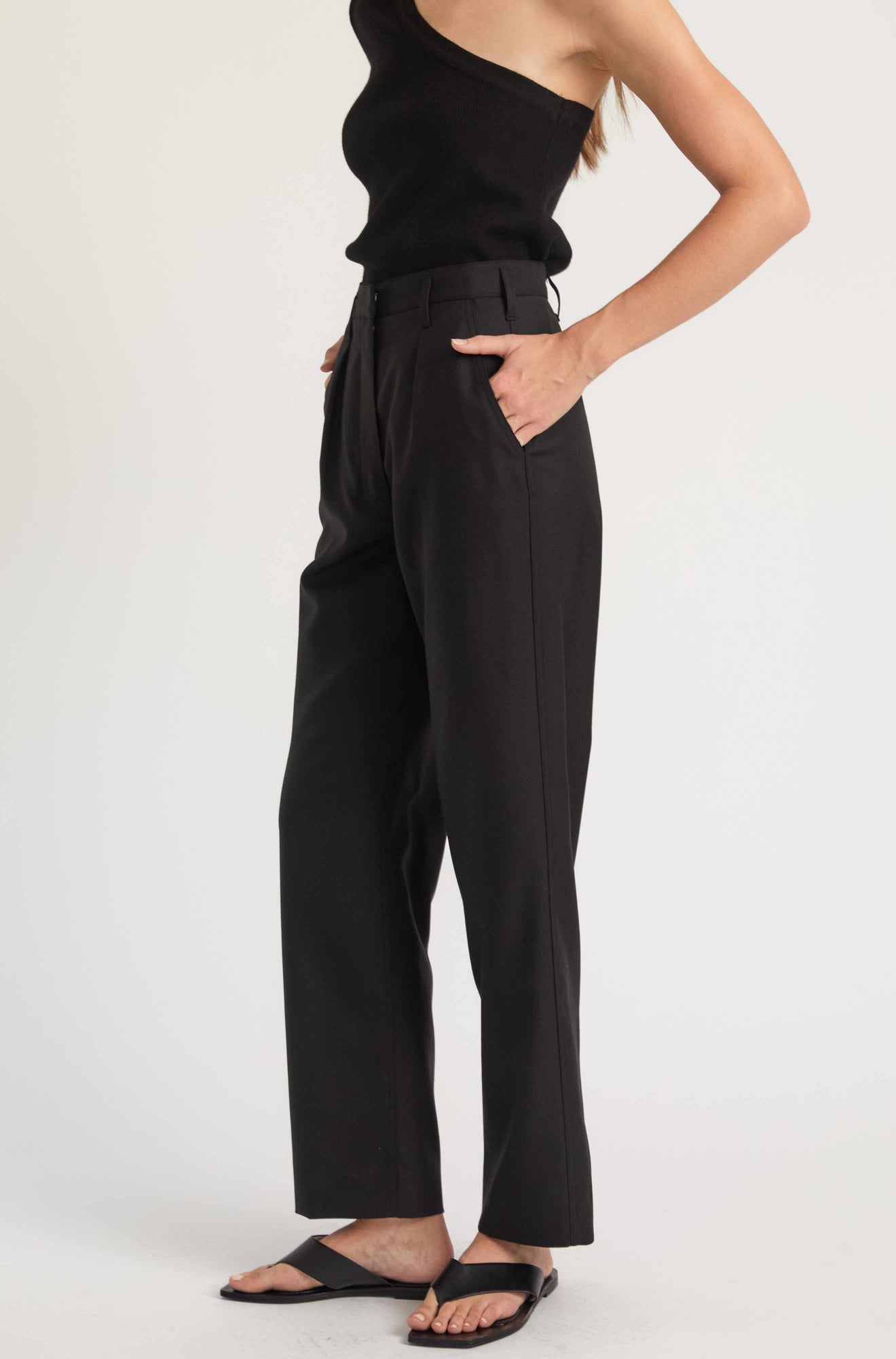 Person wearing black high-waisted pants on a white background