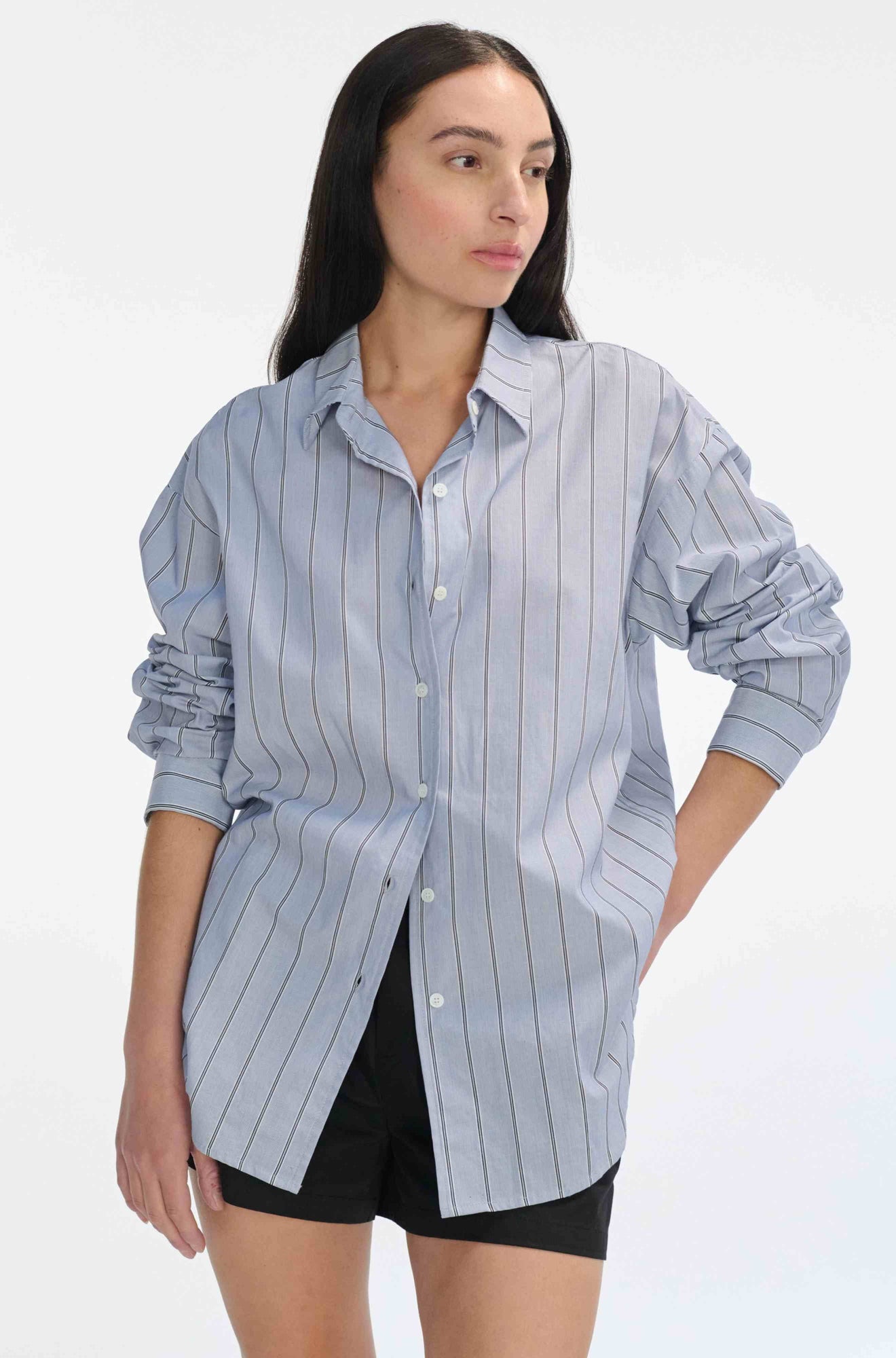 Woman wearing a light blue striped shirt on a white background
