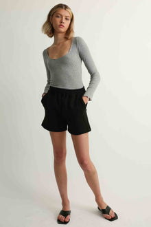 Woman wearing black shorts and a grey tee
