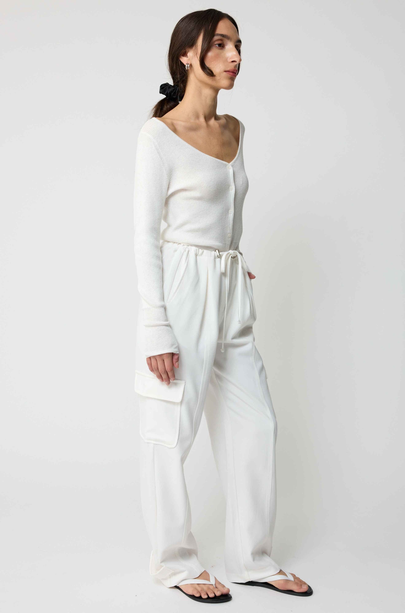 Woman wearing a white outfit against a plain background