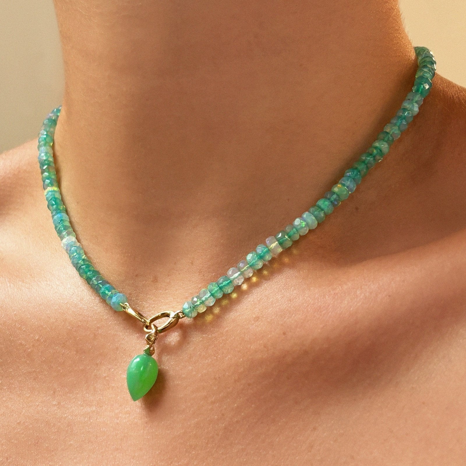 Shimmering beaded necklace made of faceted opals in shades of Blue, Teal, green and pale blue on a gold linking ovals clasp Styled with the Green Onyx acorn drop charm