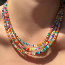 Multi-colored opal necklaces layered on the neck.