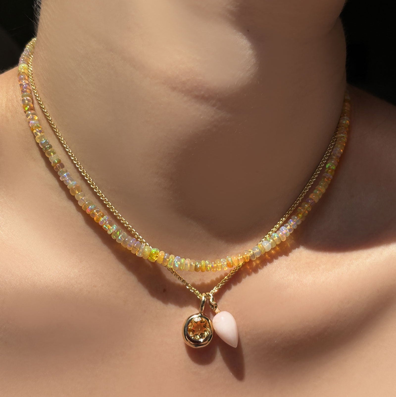 Eclipse opal necklace layered with wheat chain, pink opal drop charm, citrine molten solitaire charm on the neck.