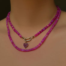 Fuchsia opals with a ruby pavé heart charm hanging from a ruby charm lock on the neck.