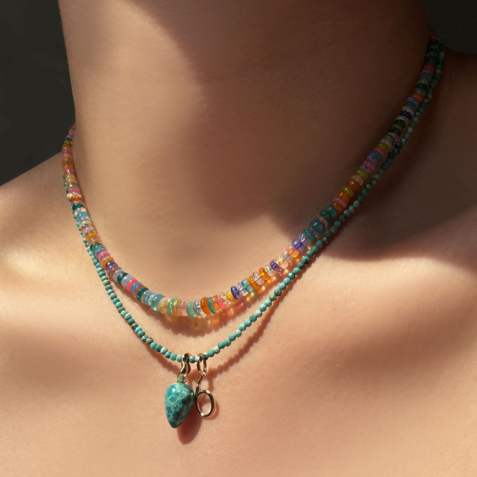 Garden party opal necklace layered with a slim turquoise gemstone necklace, with chrysocolla and number charm hanging on the neck