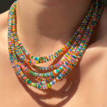 Layers of multiple garden party opal necklaces on the neck.