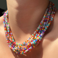 High-biscus multi-colored opal necklaces layered on the neck.