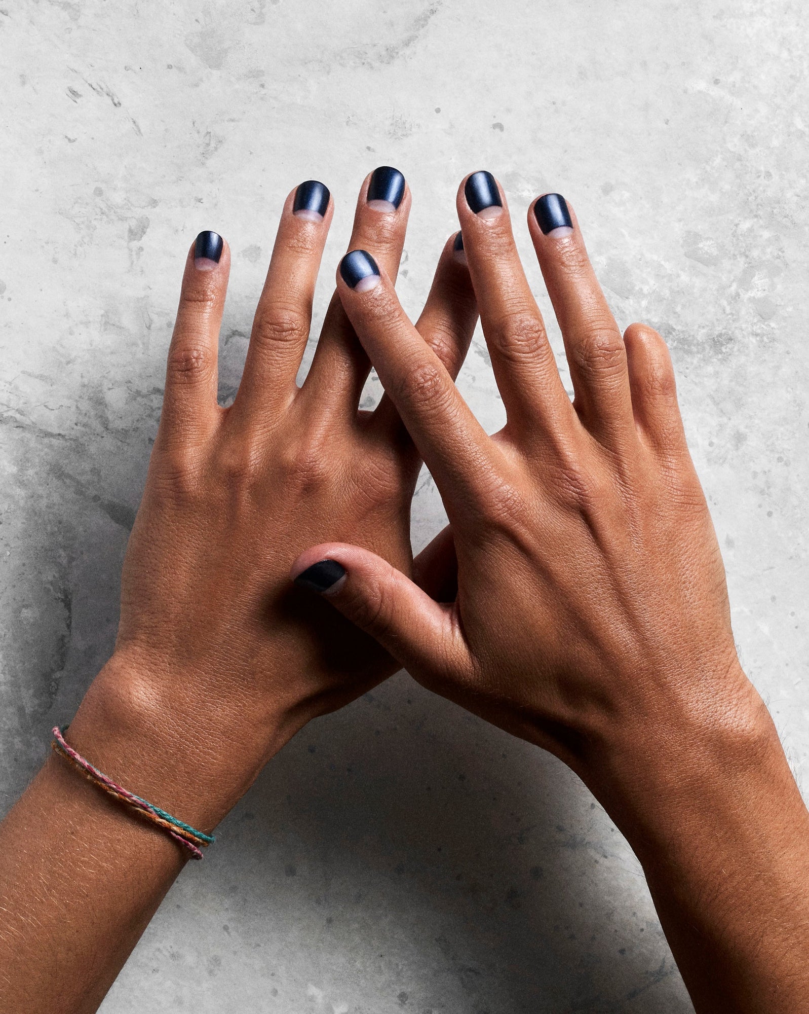 Overhead view of two hands with nails painted black