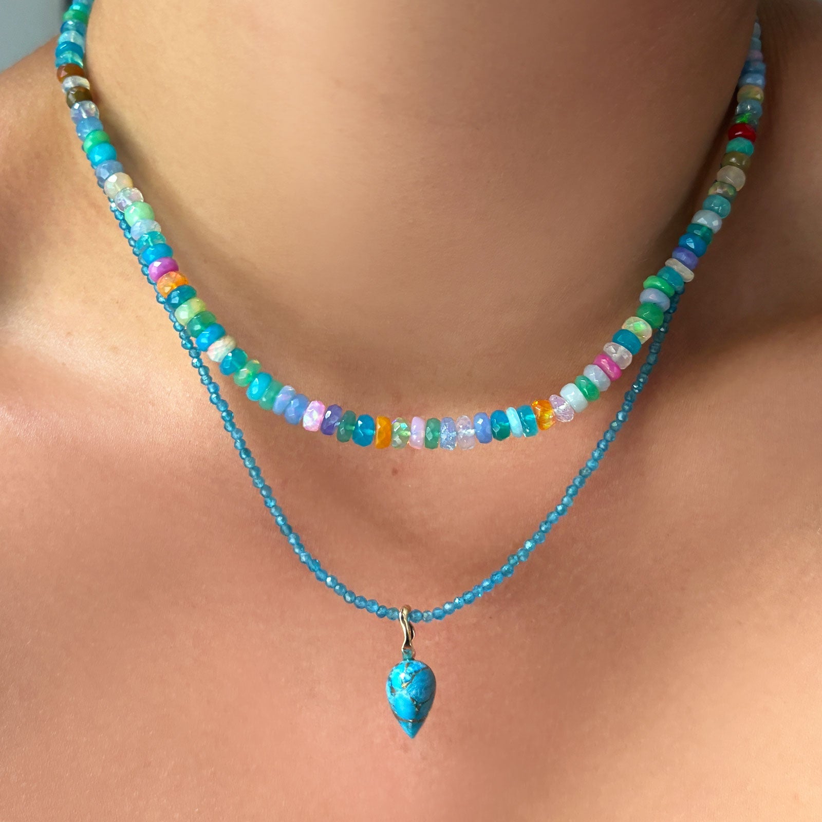 santorini faceted opal necklace layered with blue apatite slim gemstone necklace and Turquoise Drop Charm on the neck.