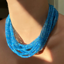 Shimmering beaded opal necklace made of smooth opals in shades of blue on a gold slim lobster clasp styled on a neck layered together