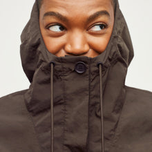Detail image of a woman standing wearing the Britt Hoodie—AirTech in Dark Moss